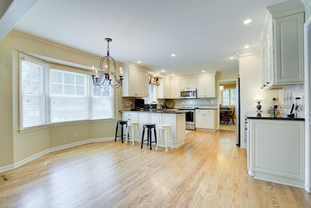 1056 Whirlaway Ave, Naperville, IL 60540 - kitchen with dark countertops, appliances with stainless steel finishes, crown molding, backsplash, and a chandelier