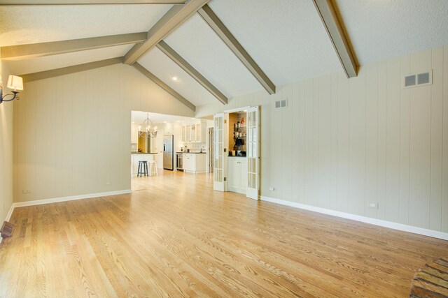 1056 Whirlaway Ave, Naperville, IL 60540 - unfurnished living room with a chandelier, light wood-style flooring, and baseboards