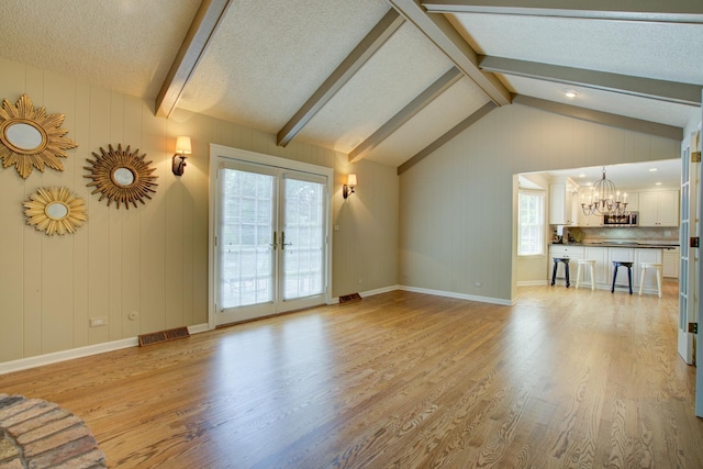 1056 Whirlaway Ave, Naperville, IL 60540 - unfurnished living room featuring a chandelier, light wood-style flooring, french doors, and a textured ceiling