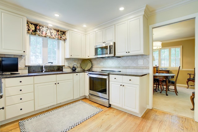 1056 Whirlaway Ave, Naperville, IL 60540 - kitchen featuring appliances with stainless steel finishes, a sink, ornamental molding, light wood-style flooring, and white cabinets