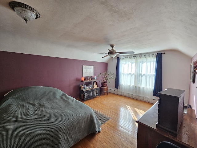 130 First St, Cary, IL 60013 - bedroom featuring hardwood / wood-style flooring, vaulted ceiling, a textured ceiling, a baseboard heating unit, and ceiling fan