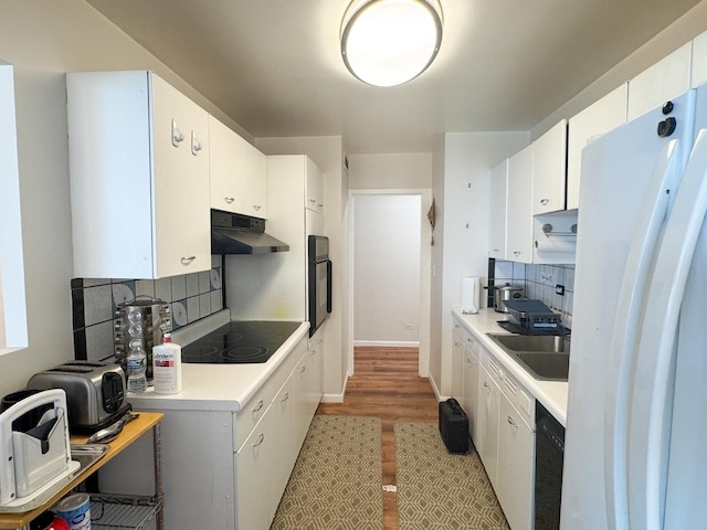 6301 N Sheridan Rd Unit 14E, Chicago, IL 60660 - kitchen with under cabinet range hood, black appliances, a sink, decorative backsplash, and white cabinetry