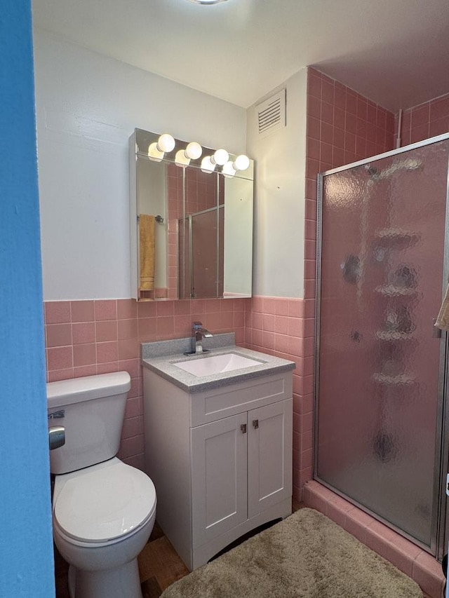 6301 N Sheridan Rd Unit 14E, Chicago, IL 60660 - full bath with tile walls, vanity, a shower stall, toilet, and a wainscoted wall