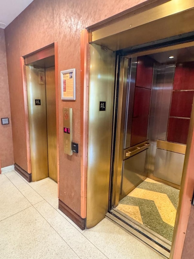6301 N Sheridan Rd Unit 14E, Chicago, IL 60660 - hall with dark speckled floor, elevator, and baseboards