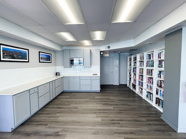 6301 N Sheridan Rd Unit 14E, Chicago, IL 60660 - kitchen featuring stainless steel microwave, backsplash, dark wood finished floors, light countertops, and a drop ceiling