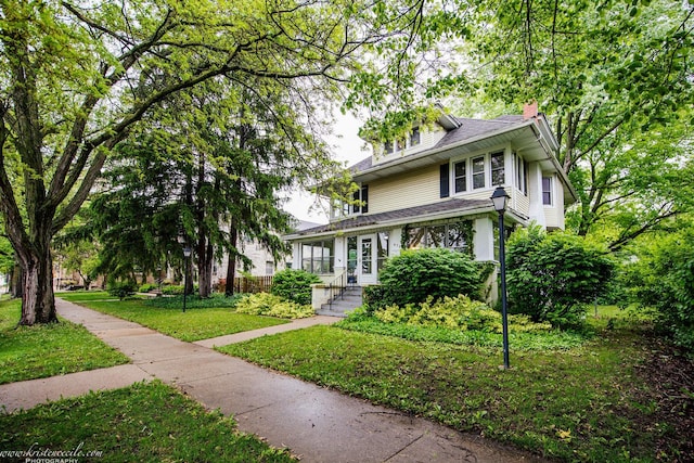 456 S Indiana Ave, Kankakee, IL 60901 - traditional style home with a chimney, a front lawn, and roof with shingles