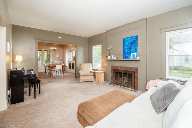 456 S Indiana Ave, Kankakee, IL 60901 - living room featuring a chandelier, light colored carpet, a brick fireplace, and baseboards