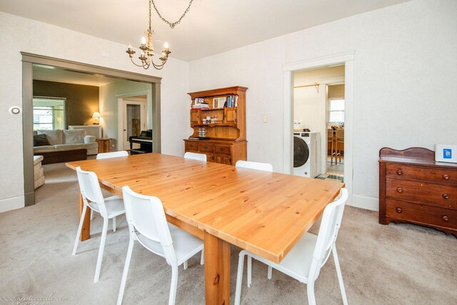 456 S Indiana Ave, Kankakee, IL 60901 - dining room featuring light colored carpet, a chandelier, and washer / dryer