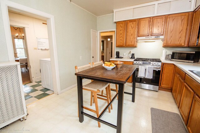 456 S Indiana Ave, Kankakee, IL 60901 - kitchen featuring stainless steel appliances, light floors, under cabinet range hood, a chandelier, and brown cabinets