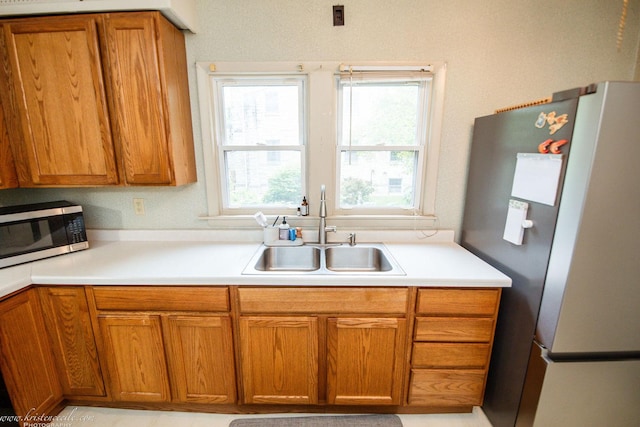 456 S Indiana Ave, Kankakee, IL 60901 - kitchen with stainless steel appliances, a sink, brown cabinetry, and light countertops