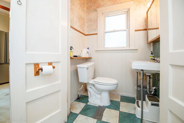456 S Indiana Ave, Kankakee, IL 60901 - bathroom with wainscoting, wallpapered walls, toilet, a decorative wall, and baseboards
