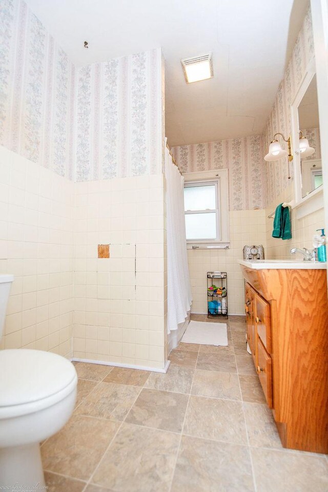 456 S Indiana Ave, Kankakee, IL 60901 - full bath featuring tile walls, toilet, vanity, wallpapered walls, and curtained shower