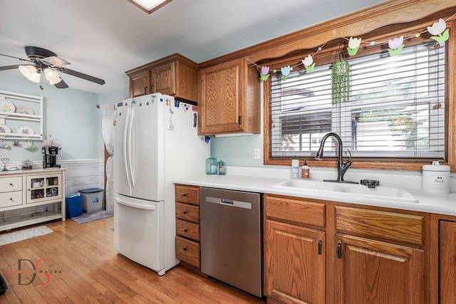 907 Parks Ln, Ottawa, IL 61350 - kitchen with stainless steel dishwasher, freestanding refrigerator, a sink, brown cabinets, and a ceiling fan