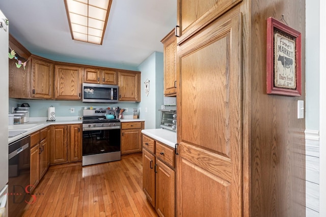 907 Parks Ln, Ottawa, IL 61350 - kitchen featuring stainless steel appliances, light wood-style flooring, light countertops, and brown cabinetry