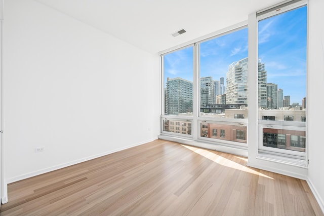 500 W Superior St Unit 805, Chicago, IL 60654 - empty room featuring a view of skyline, wood finished floors, expansive windows, and baseboards
