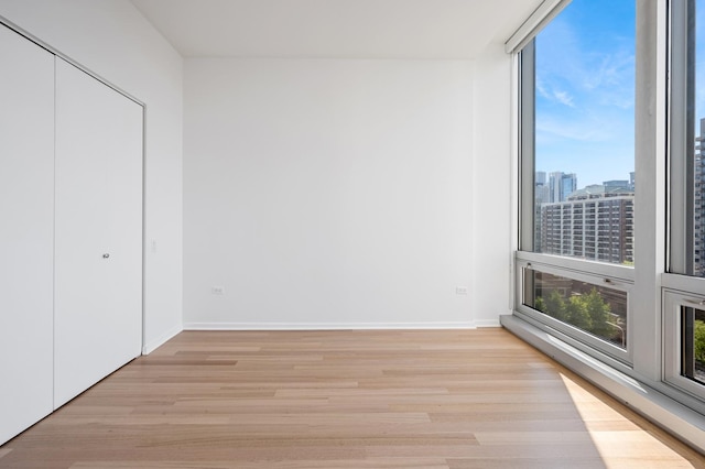 500 W Superior St Unit 805, Chicago, IL 60654 - unfurnished bedroom with multiple windows, light wood-style floors, and a closet