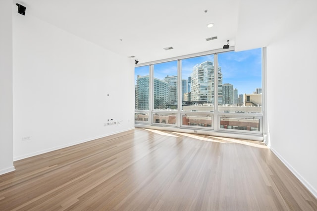 500 W Superior St Unit 805, Chicago, IL 60654 - unfurnished room featuring a skyline view, wood finished floors, a wall of windows, and baseboards