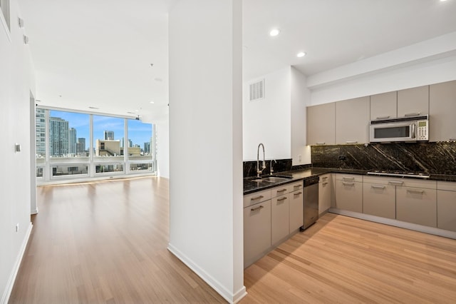500 W Superior St Unit 805, Chicago, IL 60654 - kitchen featuring a sink, stainless steel appliances, light wood-style floors, gray cabinets, and decorative backsplash