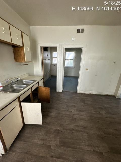 11739 S Indiana Ave, Chicago, IL 60628 - kitchen with white cabinets, dark wood-style floors, light countertops, and a sink