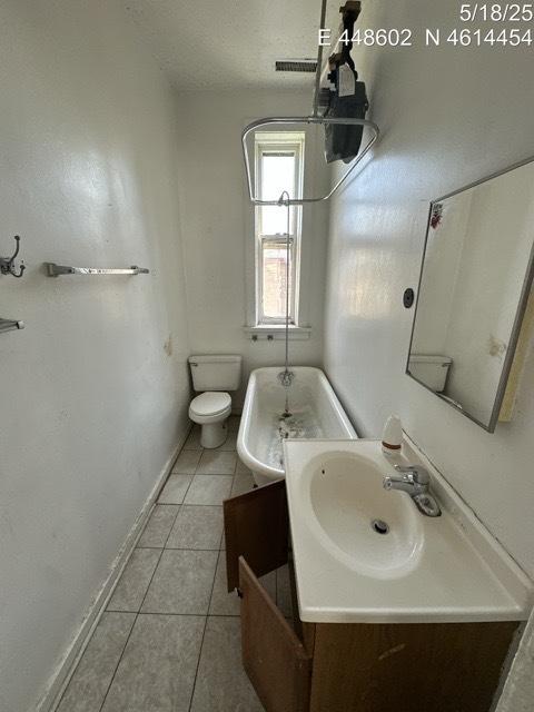 11739 S Indiana Ave, Chicago, IL 60628 - bathroom with vanity, toilet, tile patterned flooring, and baseboards