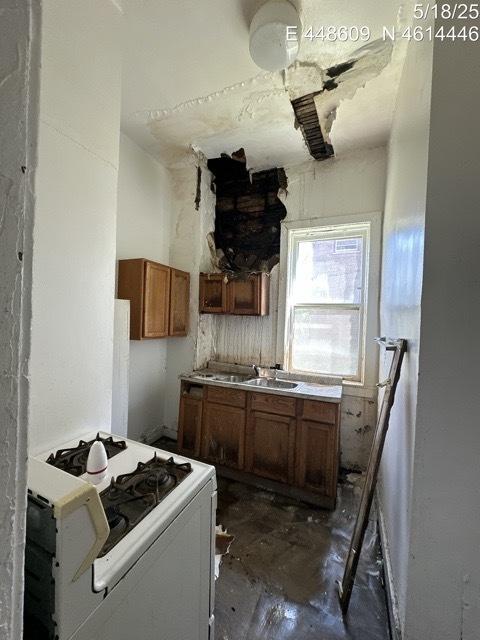 11739 S Indiana Ave, Chicago, IL 60628 - kitchen with white gas range, brown cabinets, and a sink