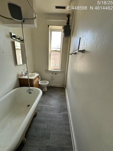 11739 S Indiana Ave, Chicago, IL 60628 - full bath with a freestanding tub, baseboards, toilet, vanity, and wood finished floors
