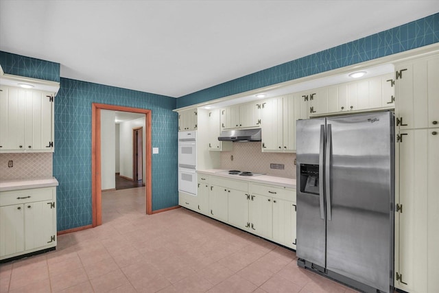 1651 Phillips Woods Ln, Urbana, IL 61802 - kitchen with white appliances, under cabinet range hood, light countertops, tasteful backsplash, and cream cabinets