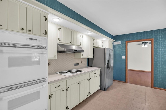1651 Phillips Woods Ln, Urbana, IL 61802 - kitchen with under cabinet range hood, stovetop, light countertops, stainless steel fridge, and ceiling fan