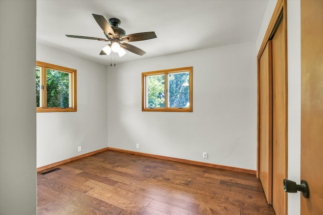 1651 Phillips Woods Ln, Urbana, IL 61802 - unfurnished bedroom with multiple windows, hardwood / wood-style floors, and a ceiling fan