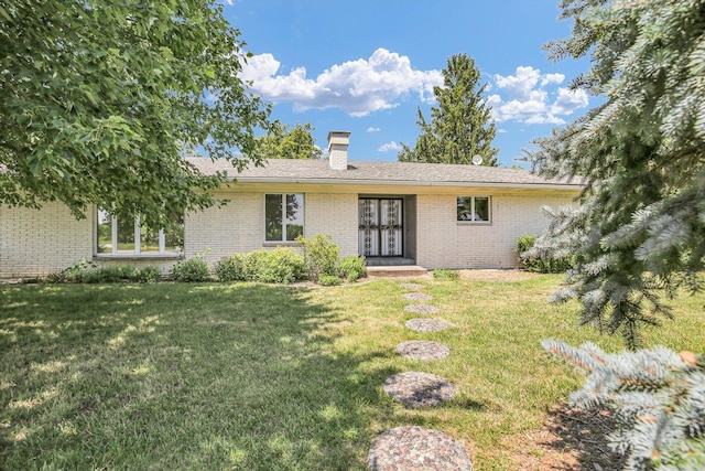 1651 Phillips Woods Ln, Urbana, IL 61802 - back of property featuring brick siding, a chimney, and a lawn