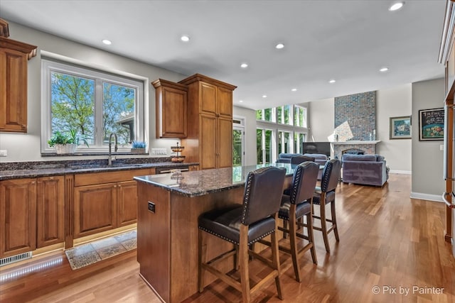 42W911 Jens Jensen Ln, Saint Charles, IL 60175 - kitchen with a sink, brown cabinets, recessed lighting, a breakfast bar, and a center island