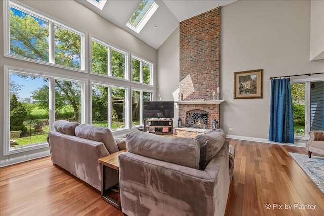 42W911 Jens Jensen Ln, Saint Charles, IL 60175 - living room featuring high vaulted ceiling, a skylight, plenty of natural light, wood finished floors, and a brick fireplace