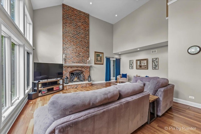 42W911 Jens Jensen Ln, Saint Charles, IL 60175 - living room with a towering ceiling, baseboards, wood finished floors, and a brick fireplace