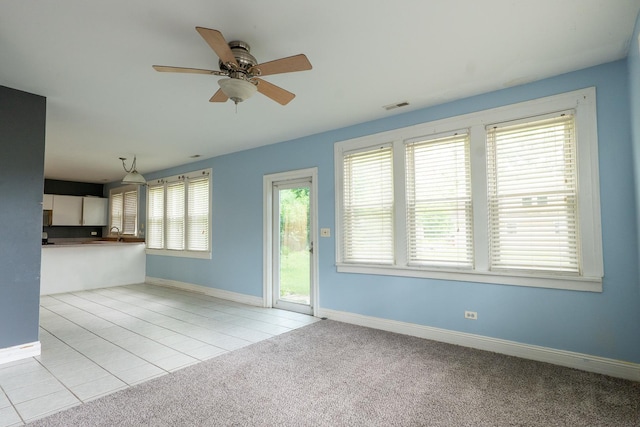2908 Oakwood Ave, Mchenry, IL 60051 - unfurnished living room with ceiling fan, a sink, baseboards, tile patterned flooring, and carpet floors