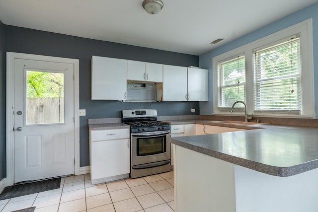 2908 Oakwood Ave, Mchenry, IL 60051 - kitchen featuring stainless steel gas range oven, a sink, white cabinets, a peninsula, and light tile patterned floors