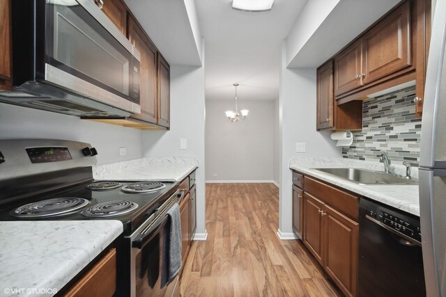 520 Shorely Dr Unit 201, Barrington, IL 60010 - kitchen with appliances with stainless steel finishes, a sink, light wood-style floors, backsplash, and light countertops
