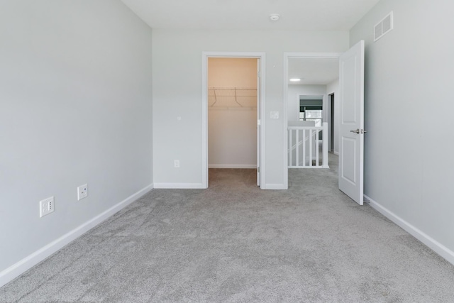 1406 Woodbine Rd Unit 1, Bloomington, IL 61704 - unfurnished bedroom with carpet, a walk in closet, baseboards, and a closet