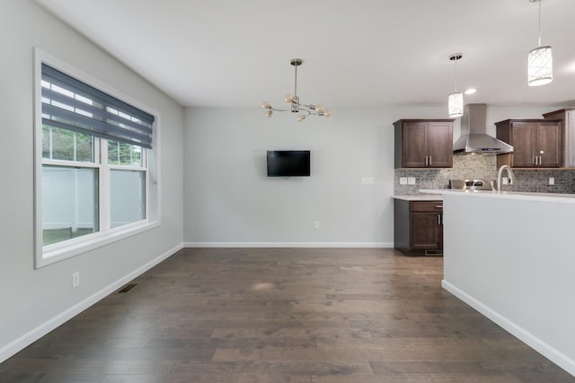 1406 Woodbine Rd Unit 1, Bloomington, IL 61704 - kitchen with wall chimney exhaust hood, dark brown cabinetry, dark wood-style floors, backsplash, and decorative light fixtures