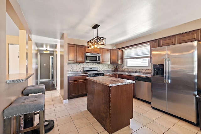 14828 Saint Louis Ave, Midlothian, IL 60445 - kitchen with stainless steel appliances, a kitchen island, light tile patterned floors, tasteful backsplash, and pendant lighting