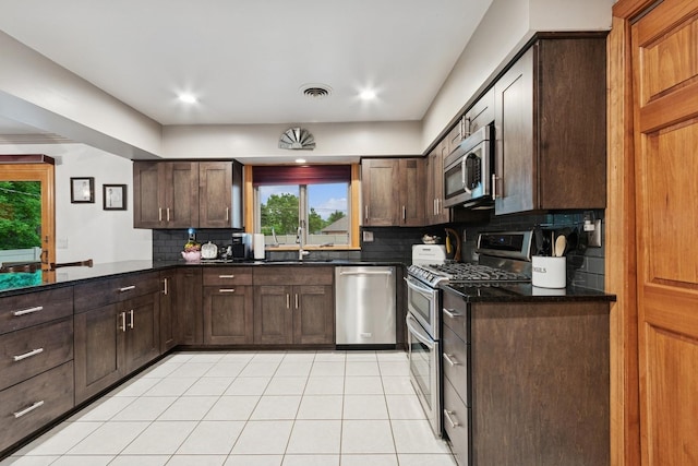 912 Murphy Dr, Joliet, IL 60435 - kitchen with stainless steel appliances, backsplash, dark brown cabinetry, and a peninsula