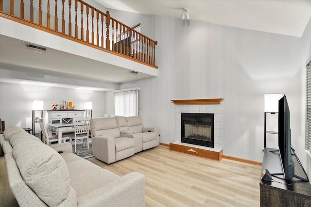 1412 Root St, Crest Hill, IL 60403 - living room with wood finished floors, a tiled fireplace, a high ceiling, and baseboards
