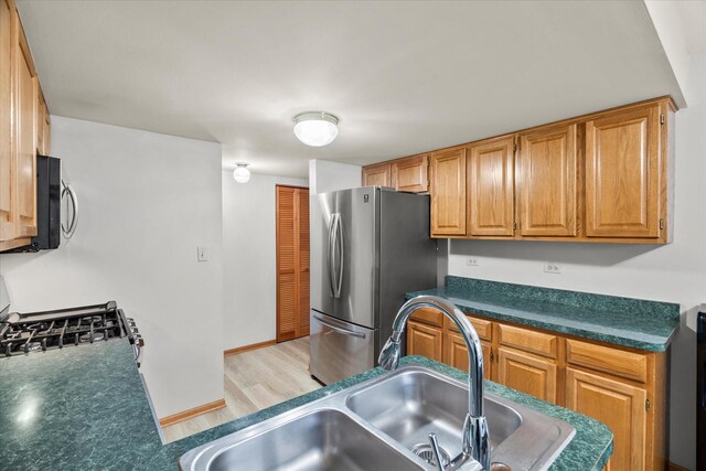 1412 Root St, Crest Hill, IL 60403 - kitchen featuring stainless steel appliances, a sink, dark countertops, baseboards, and light floors