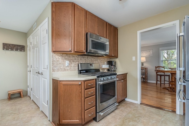9532 Lexington Ave, Brookfield, IL 60513 - kitchen featuring appliances with stainless steel finishes, light countertops, tasteful backsplash, and brown cabinets
