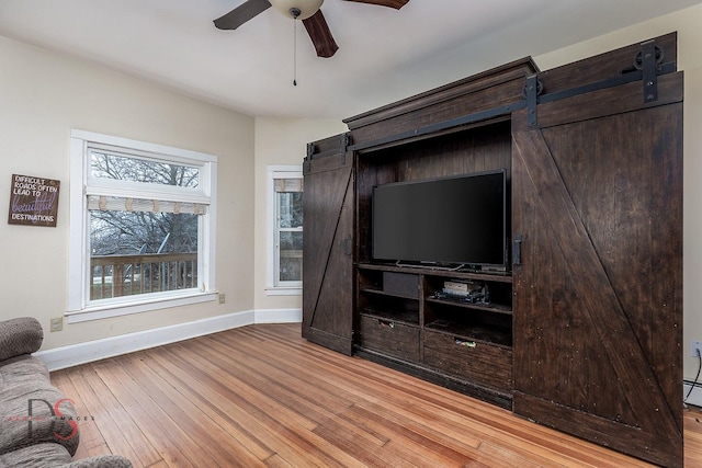 22386 N 3400 E Rd, Emington, IL 60934 - living area with baseboards, wood-type flooring, a ceiling fan, and a barn door
