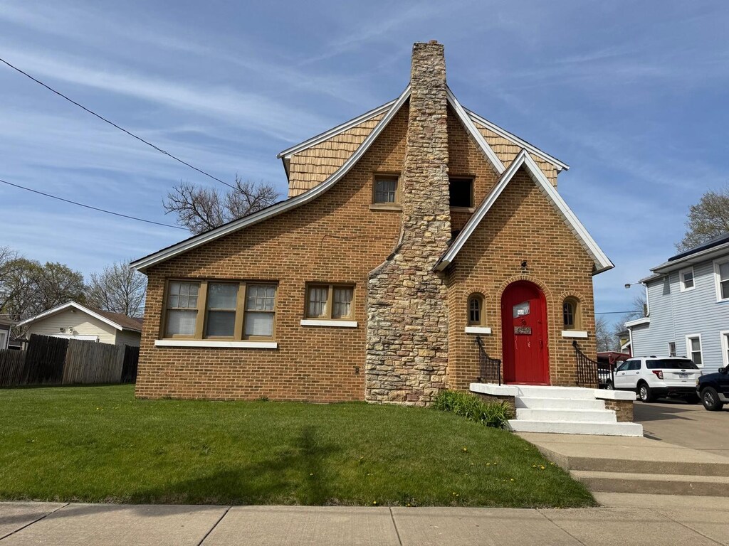 610 E Benton St, Aurora, IL 60505 - tudor home with a chimney and brick siding
