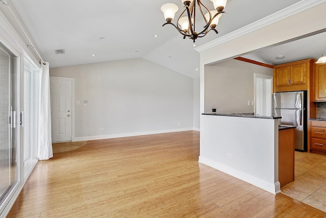 11114 Heritage Dr Unit 3C, Palos Hills, IL 60465 - kitchen featuring freestanding refrigerator, dark countertops, a chandelier, brown cabinets, and light wood-style flooring