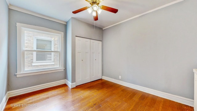 7832 S Paxton Ave, Chicago, IL 60649 - unfurnished bedroom with wood finished floors, a closet, and a ceiling fan