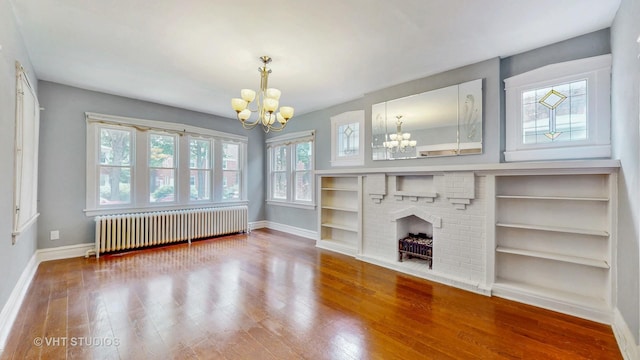 7832 S Paxton Ave, Chicago, IL 60649 - unfurnished living room with radiator, a chandelier, wood finished floors, and a fireplace