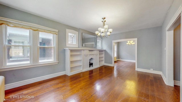 7832 S Paxton Ave, Chicago, IL 60649 - unfurnished living room with a chandelier, wood finished floors, and a fireplace