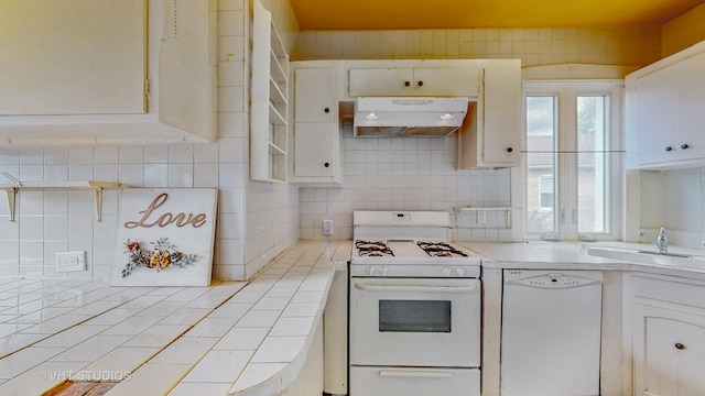 7832 S Paxton Ave, Chicago, IL 60649 - kitchen featuring white appliances, under cabinet range hood, tile countertops, decorative backsplash, and white cabinetry